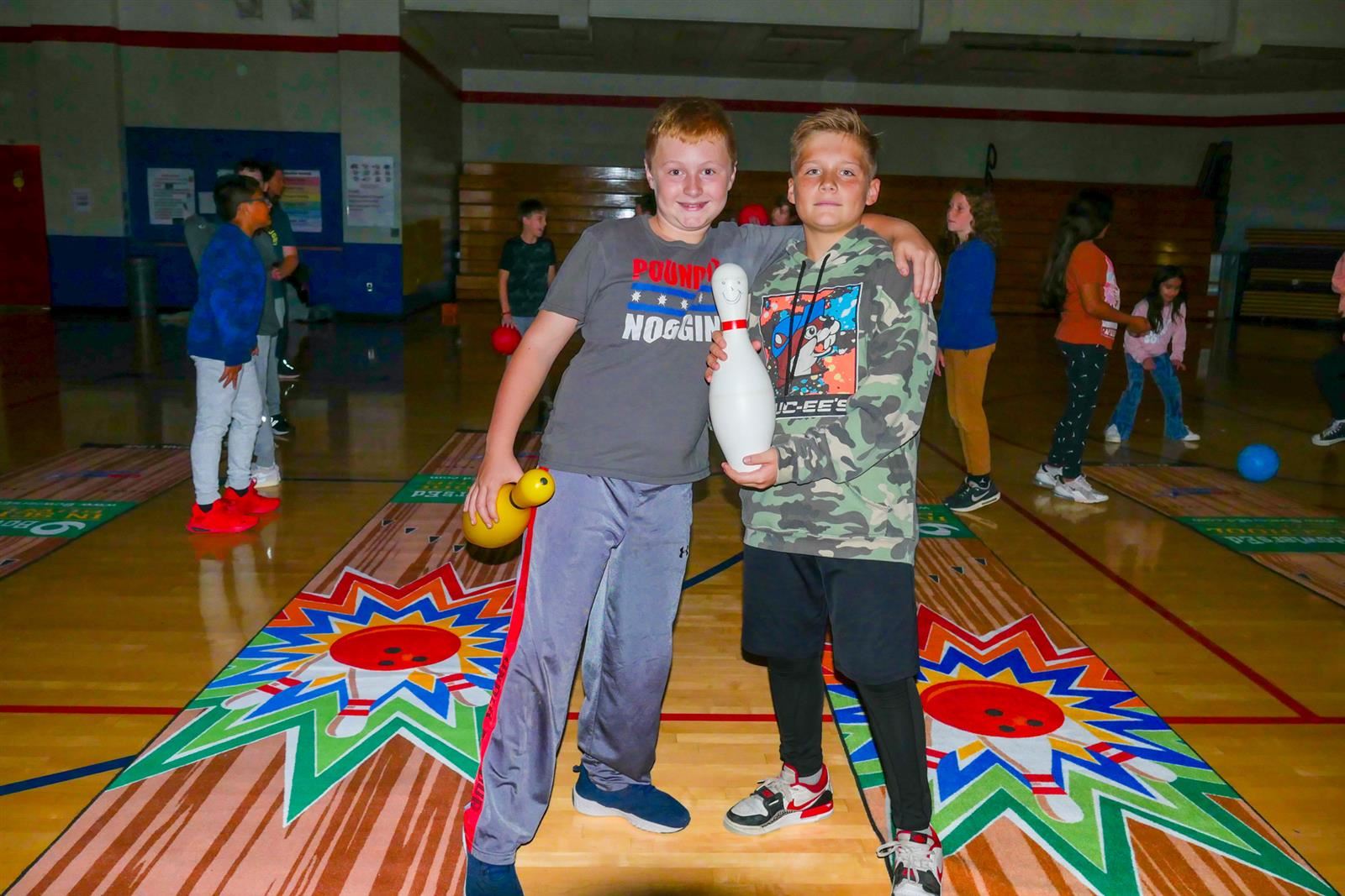 two students holding a bowling pin